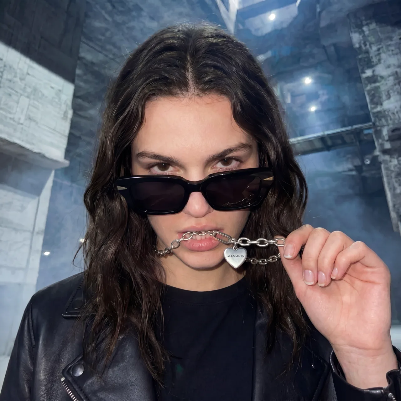 Model biting a heart pendant chain