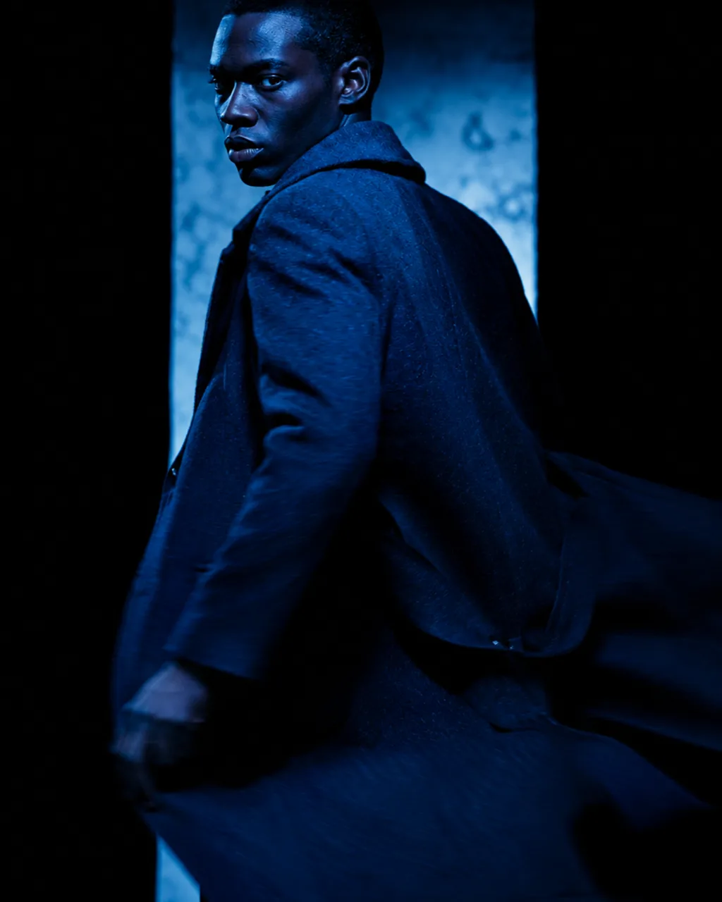 Bleu de Chanel fragrance concept campaign, model in navy tailoring at a rain-streaked window