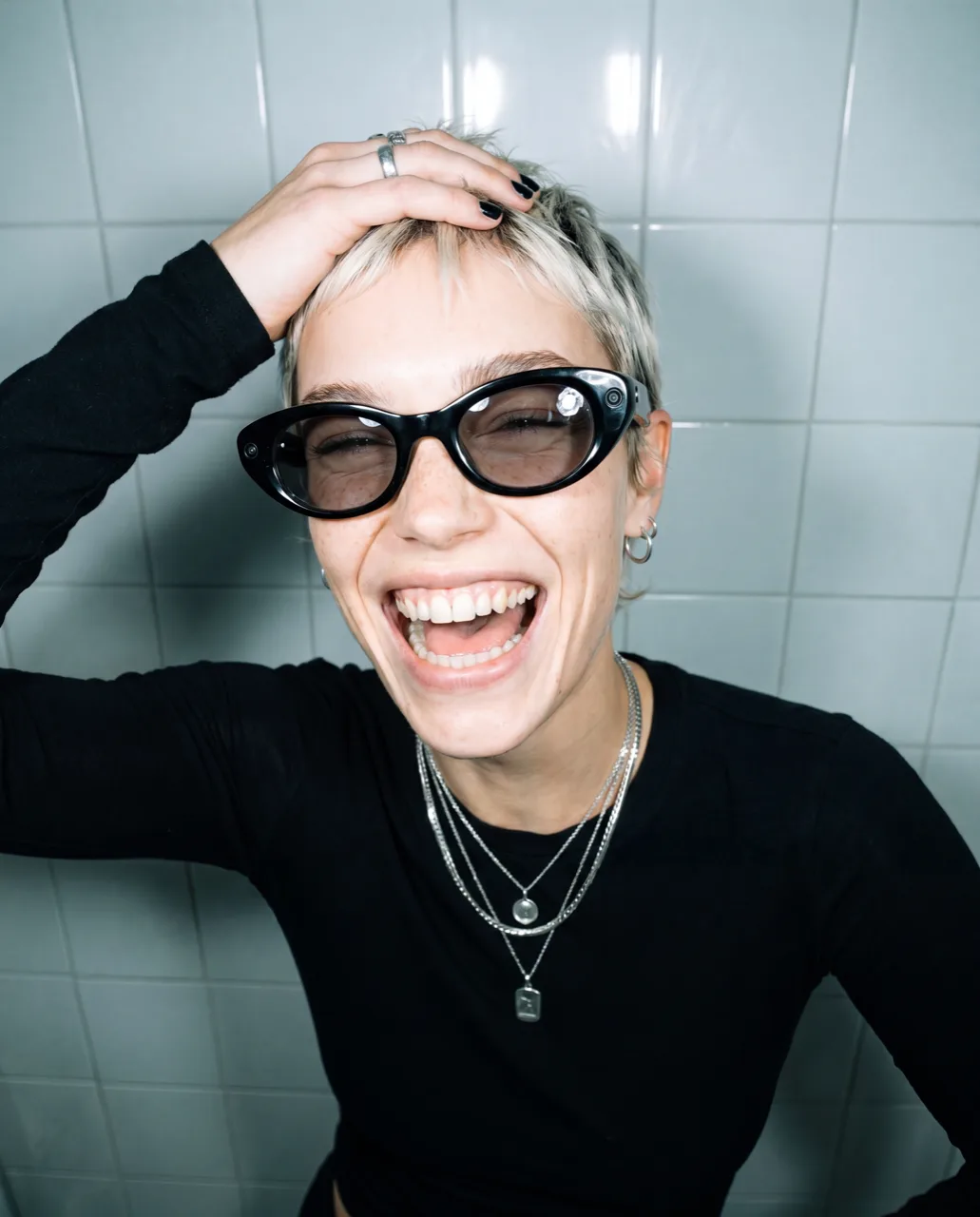 Meta smart glasses concept campaign, model laughing with a hand through cropped hair