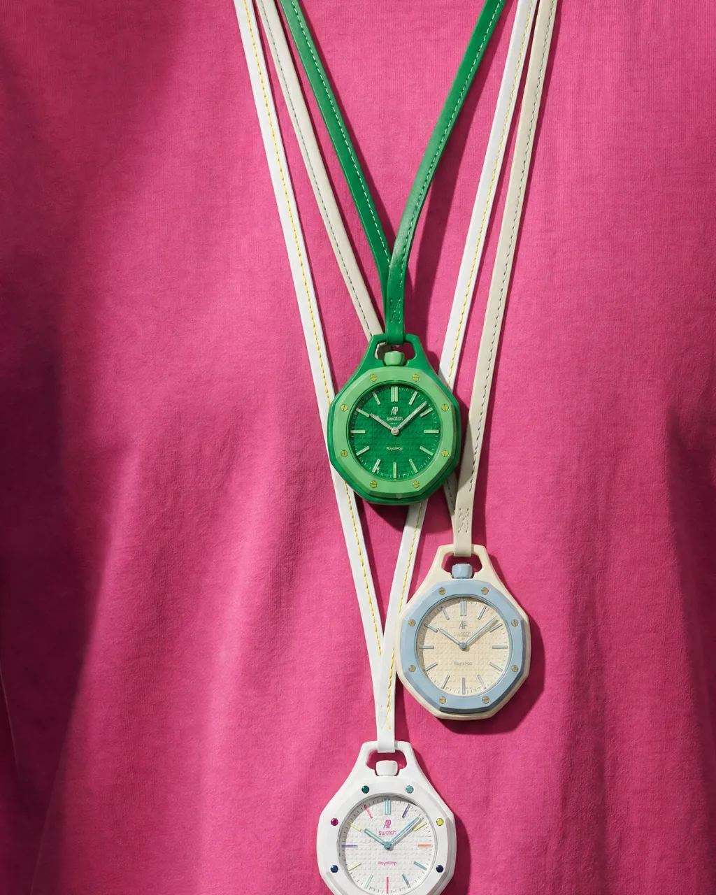 Royal POP concept campaign, watch charms worn as necklaces against fuchsia fabric