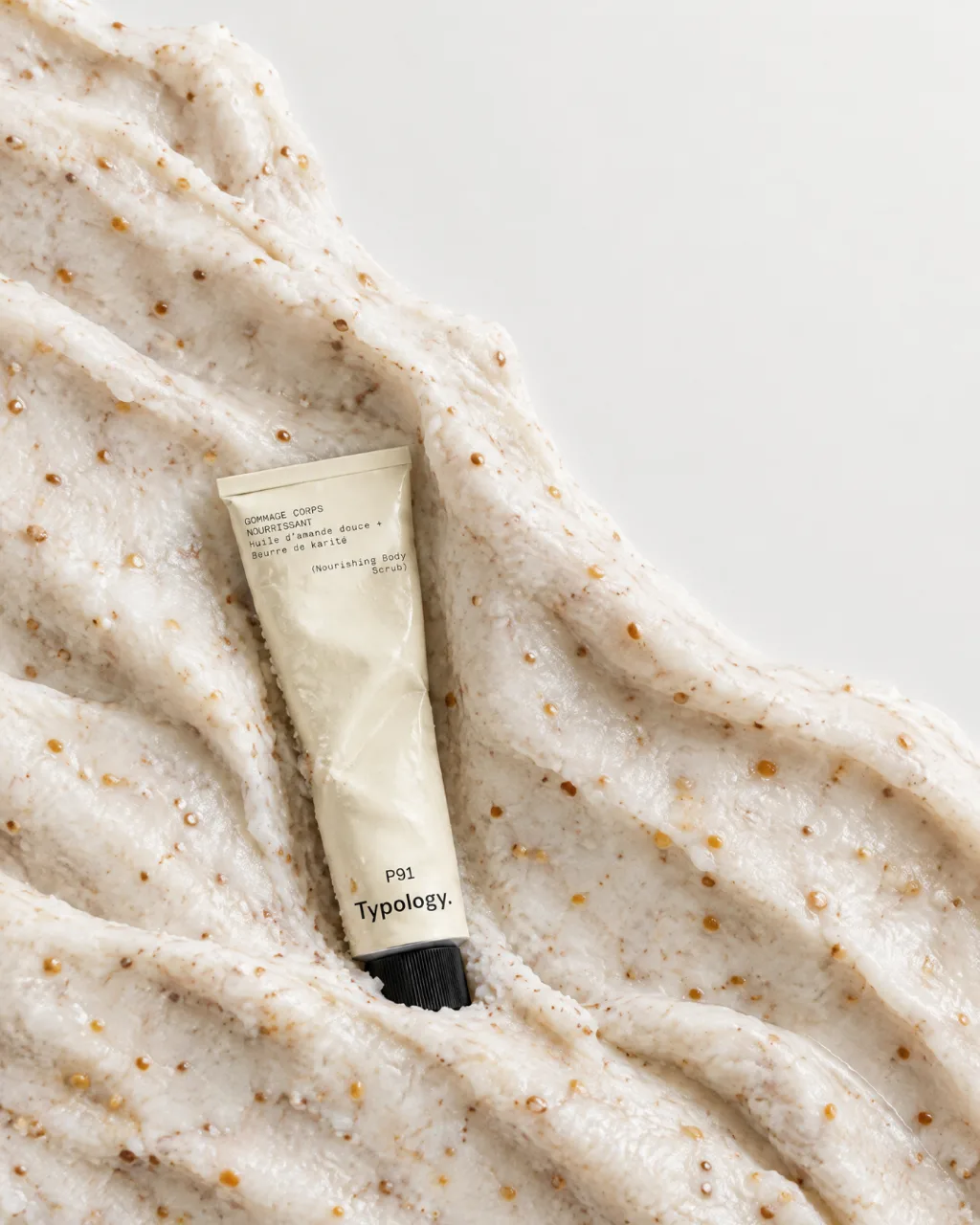 Typology P91 body scrub tube nestled in a mound of exfoliating scrub