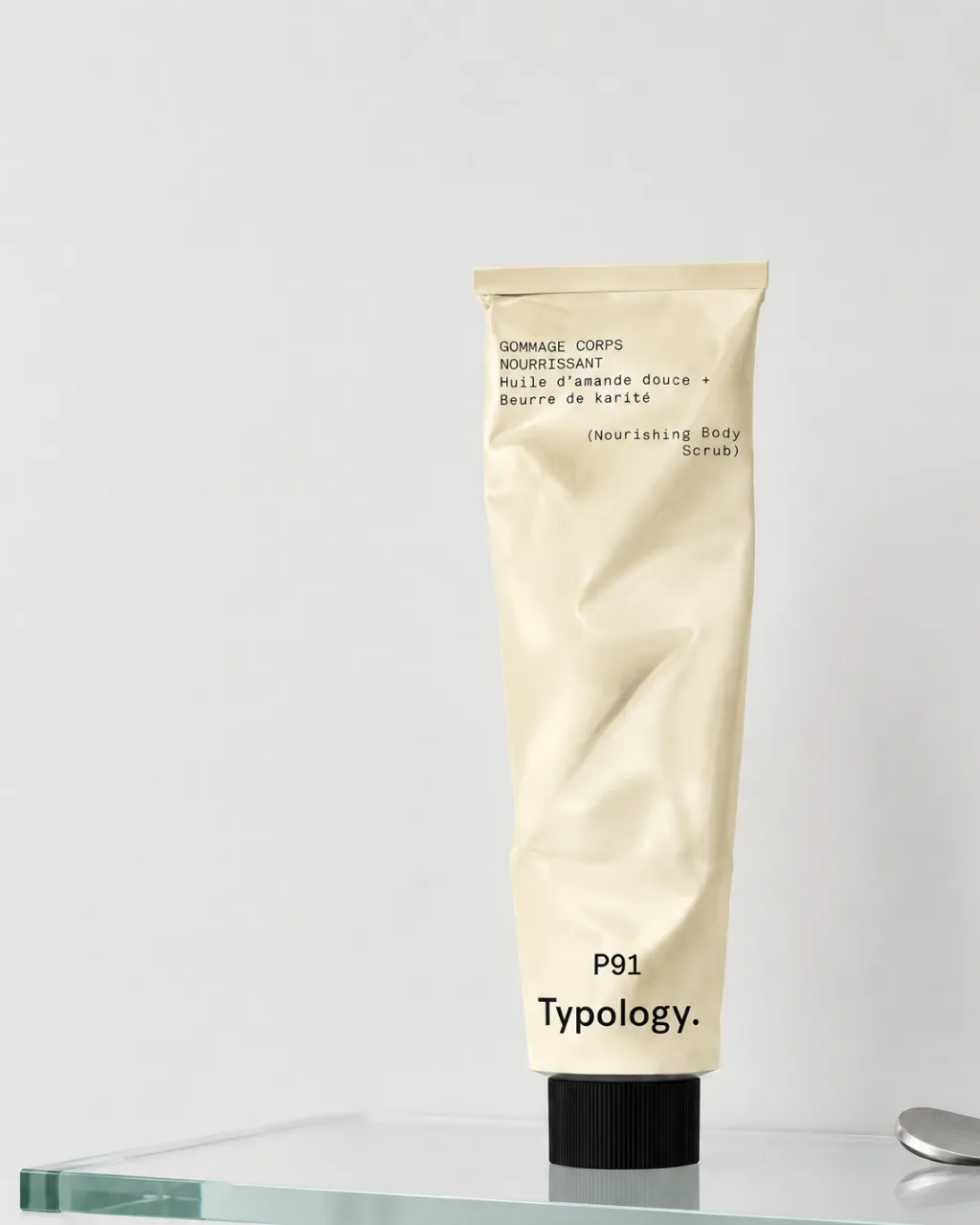 Typology P91 body scrub tube standing on a glass shelf